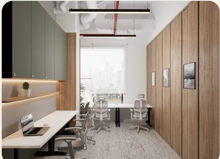 An open-plan hot desk bench under linear lighting.